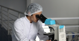 A lab technician uses a microscope